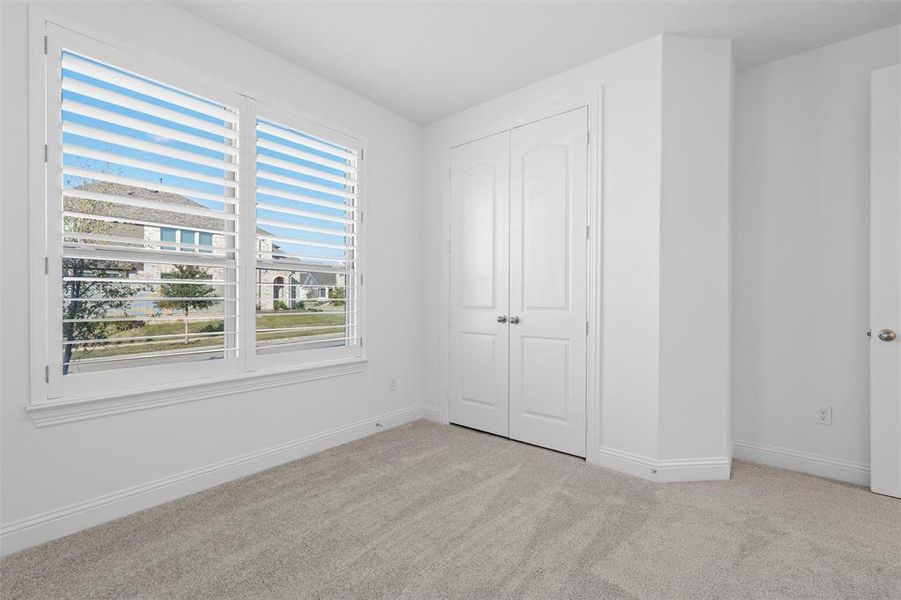 Unfurnished bedroom with a closet and light carpet