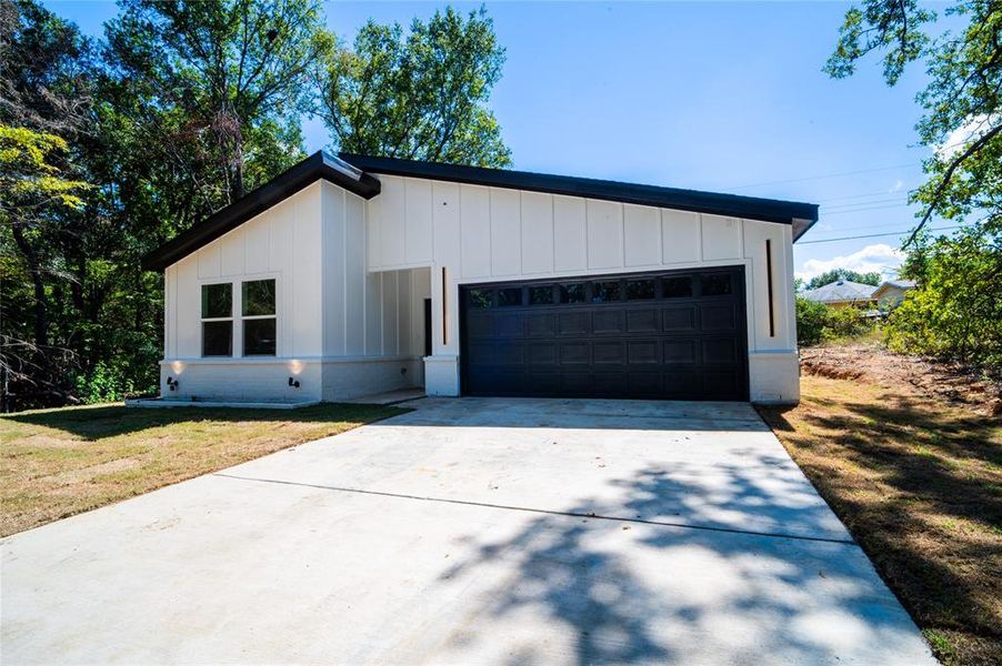 View of front of house with a front yard and a garage