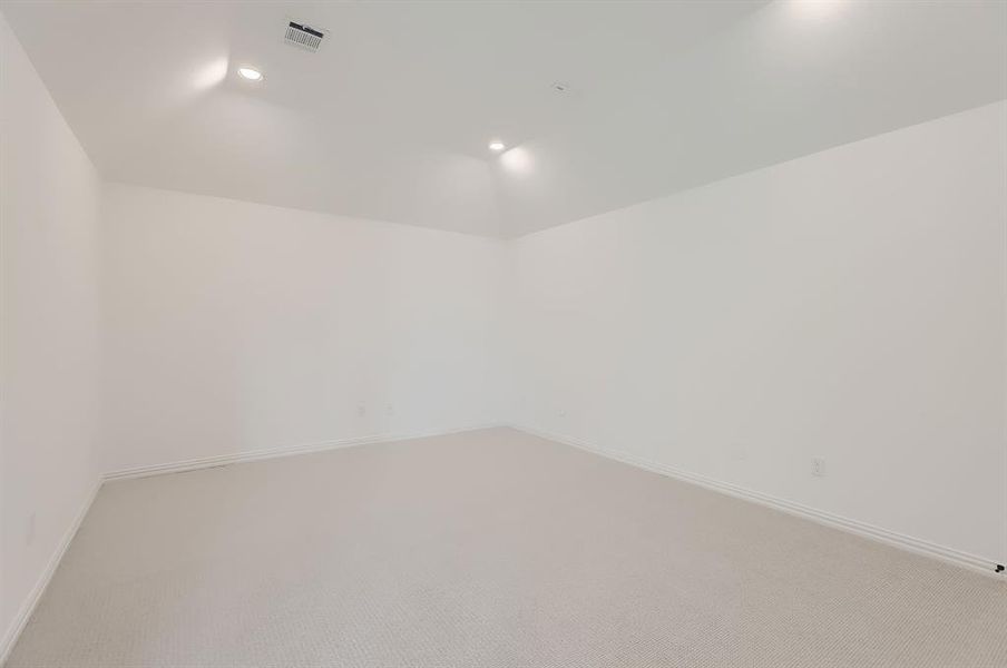 Spare room with vaulted ceiling and carpet flooring