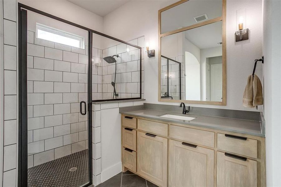 Bathroom with vanity, tile patterned flooring, and an enclosed shower