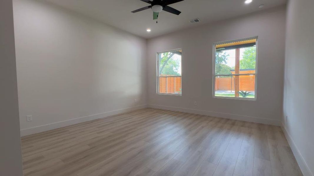 Spare room featuring plenty of natural light, ceiling fan, and wood-type flooring