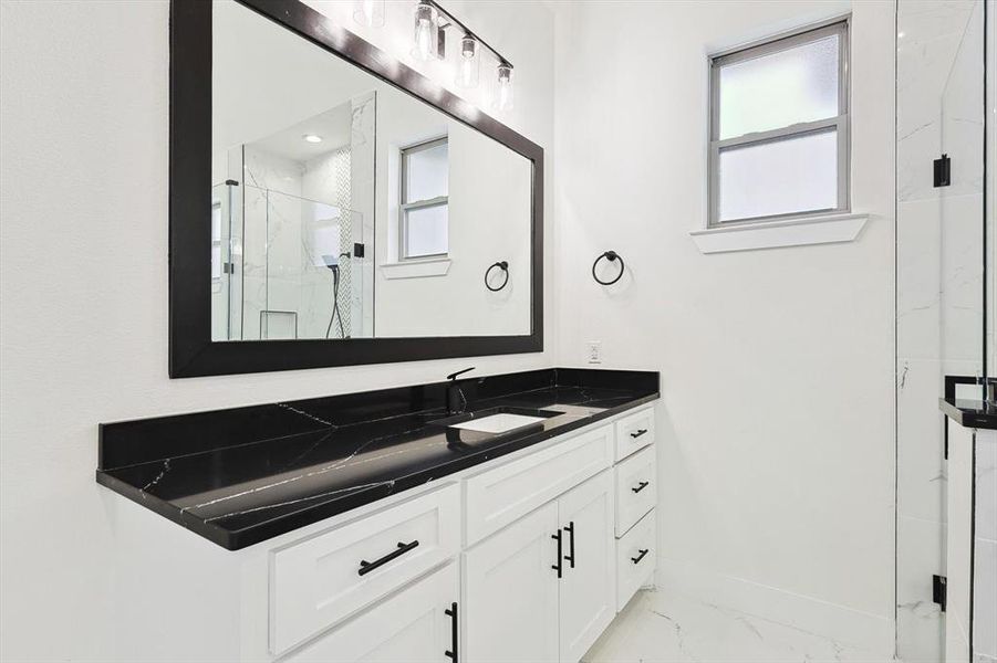 Bathroom featuring vanity and a shower with shower door