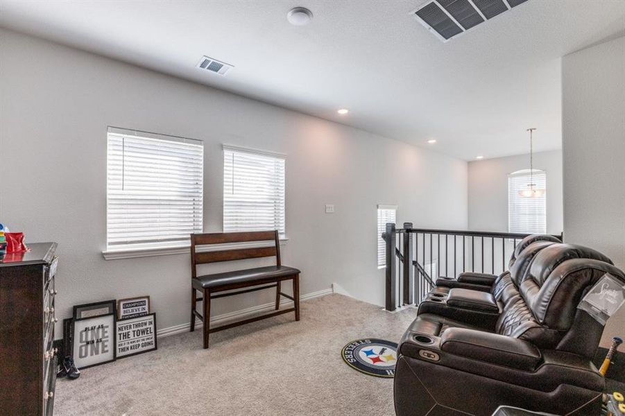 Living area featuring light colored carpet and a healthy amount of sunlight