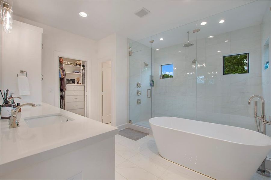 Bathroom with tile floors, vanity, and shower with separate bathtub