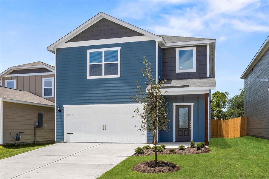 View of front of home featuring a front lawn and a garage