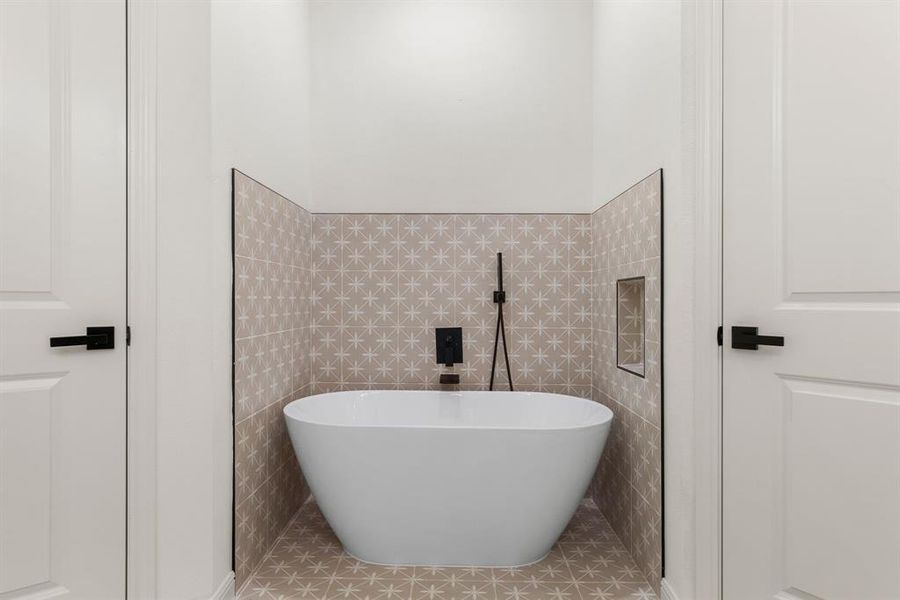 Bathroom with tile walls, a bathtub, and tile patterned floors