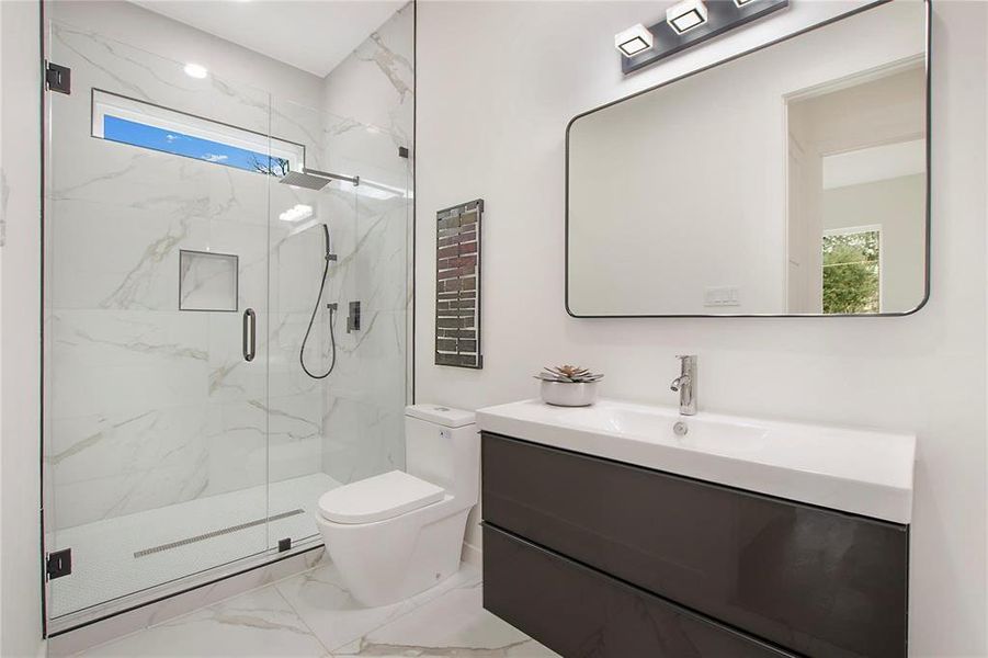 Bathroom featuring vanity, toilet, and an enclosed shower