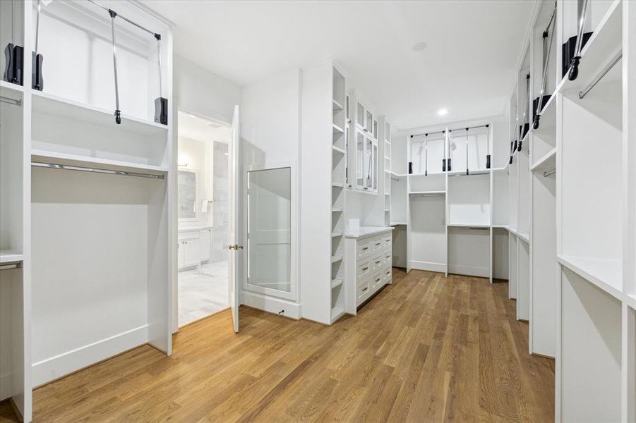An outstanding primary closet.  Adjustable shelving, pull-down rod systems, glass-front cabinetry and an abundance of drawers to make this space the ultimate in organization and enjoyment in personal space.