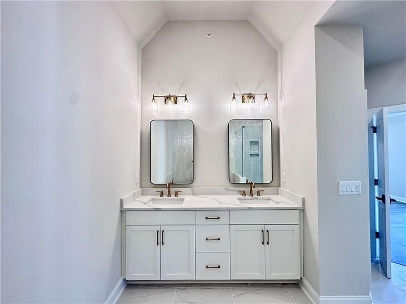 Owner suite showcases vaulted ceilings, making this the perfect space for a chandelier over your freestanding tub