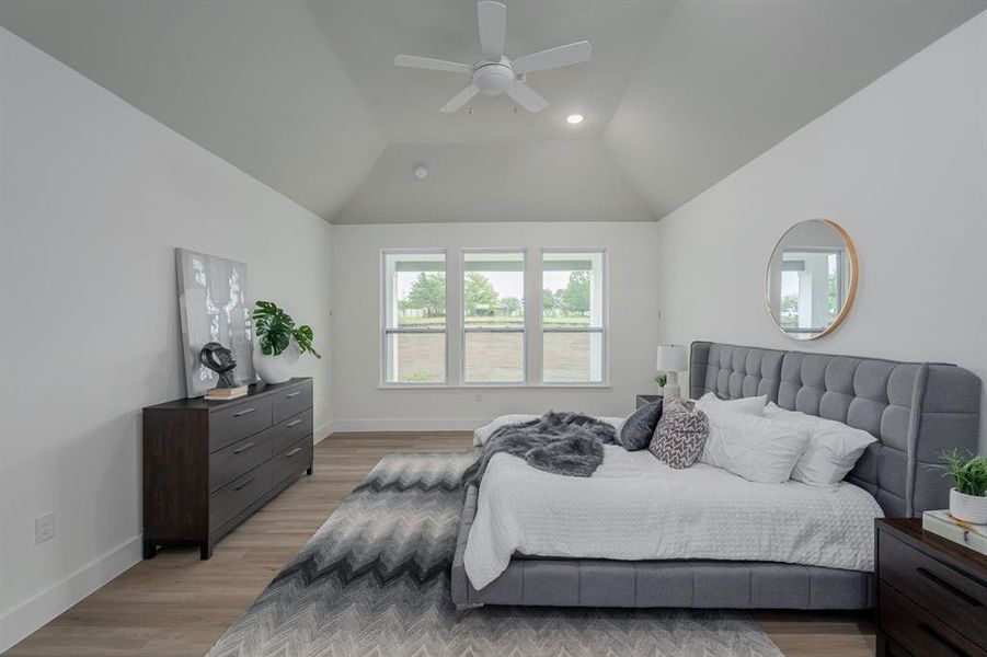 Bedroom featuring vaulted ceiling, ceiling fan, and light hardwood / wood-style floors