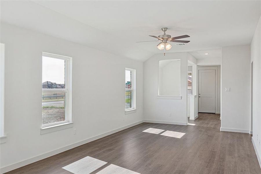 Empty room featuring ceiling fan, vaulted ceiling, and hardwood / wood-style floors