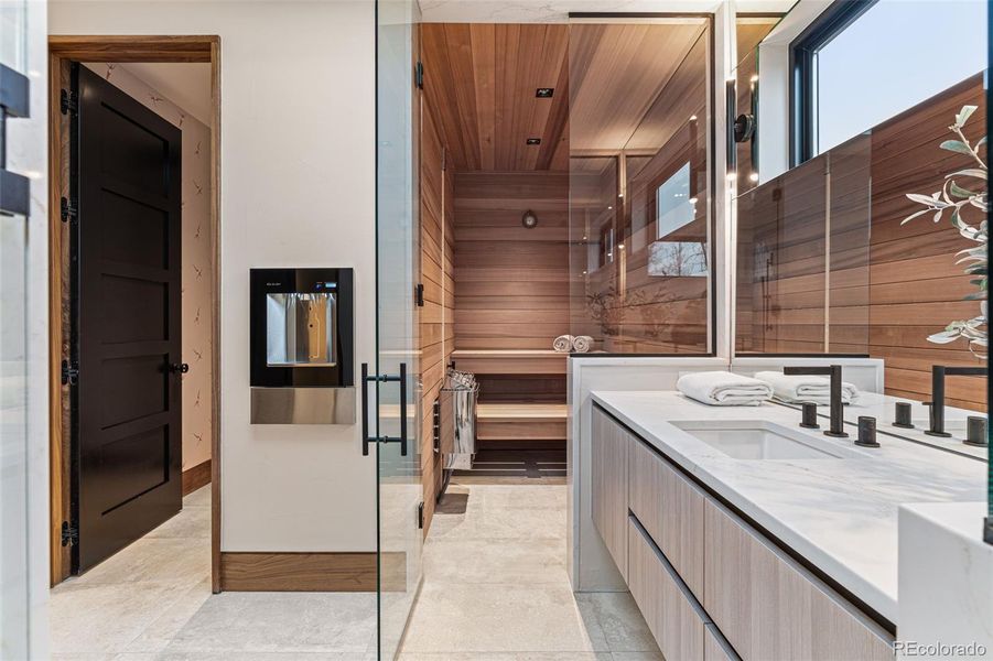 Changing room, sauna and steam shower complete this space. Elkay Built-In Filtered Water Dispenser. Eclipse by Shiloh Cabinetry, Pental Quartz Tramonto Polished Slab & Franz Viegener Faucets.