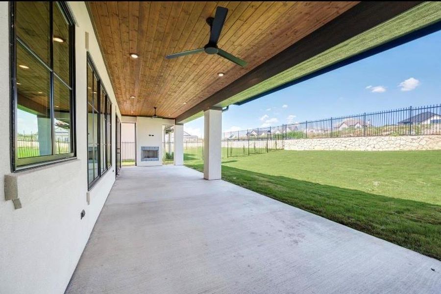 View of patio with ceiling fan and fireplace