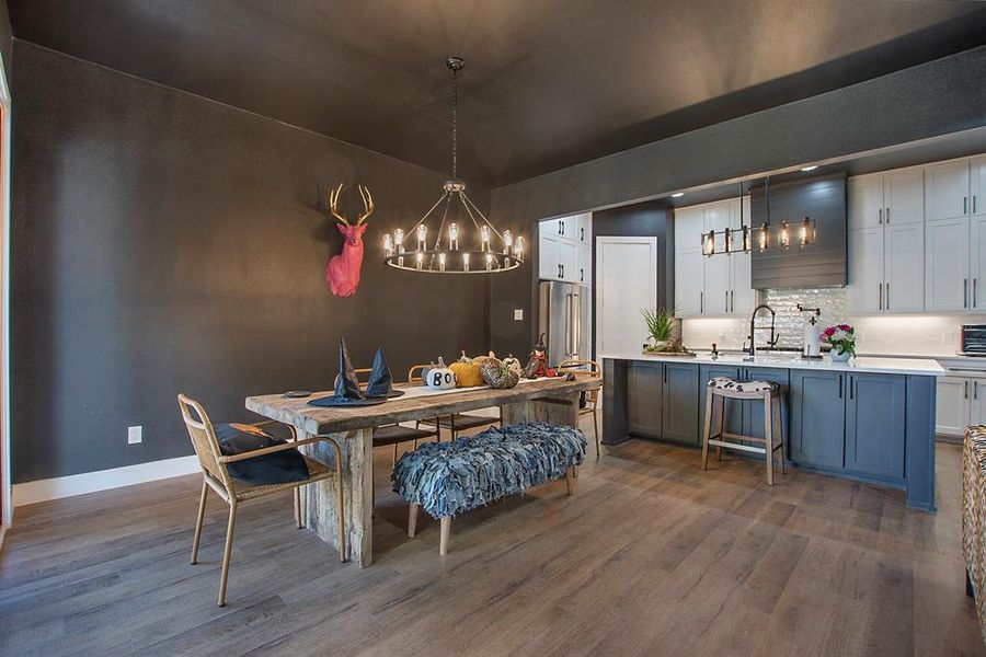 Dining space with sink and dark wood-type flooring