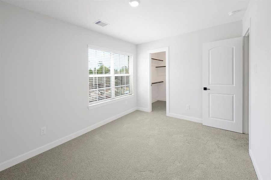 The secondary bedroom has comfortable carpet that goes with any paint color and design, and it has a large walk-in closet.