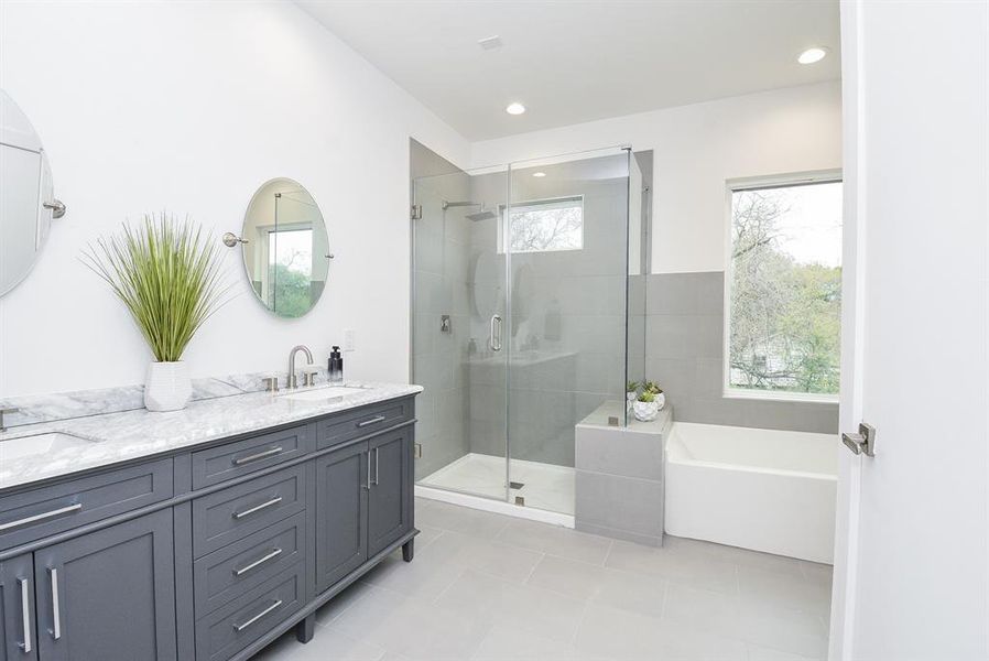 A touch of art deco inspires dual sinks, sleek hardware on cabinetry and lovely individual round wall mirrors in your primary ensuite bath.