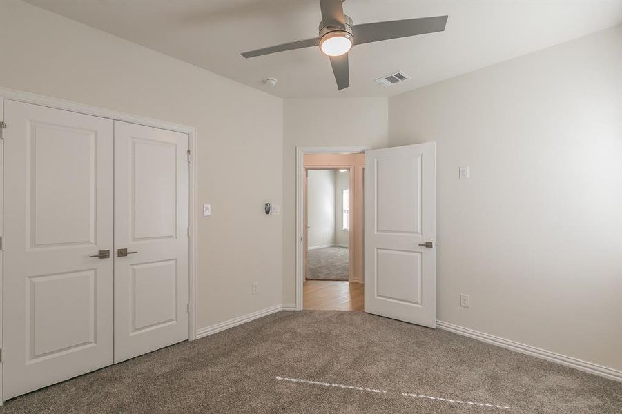 Unfurnished bedroom with light carpet, a closet, and ceiling fan