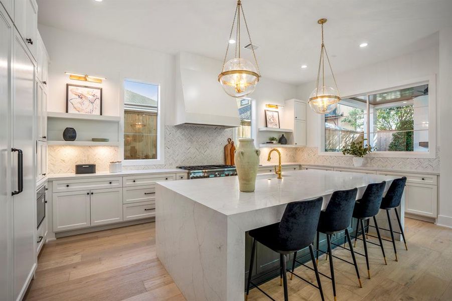 Welcome to 1804 Woodhead in the sought after River Oaks/Hyde Park neighborhood. A closer look at this quartz waterfall island with seating for 4-5 under designer pendant lighting. Oversized window overlooks your backyard covered patio and fireplace.