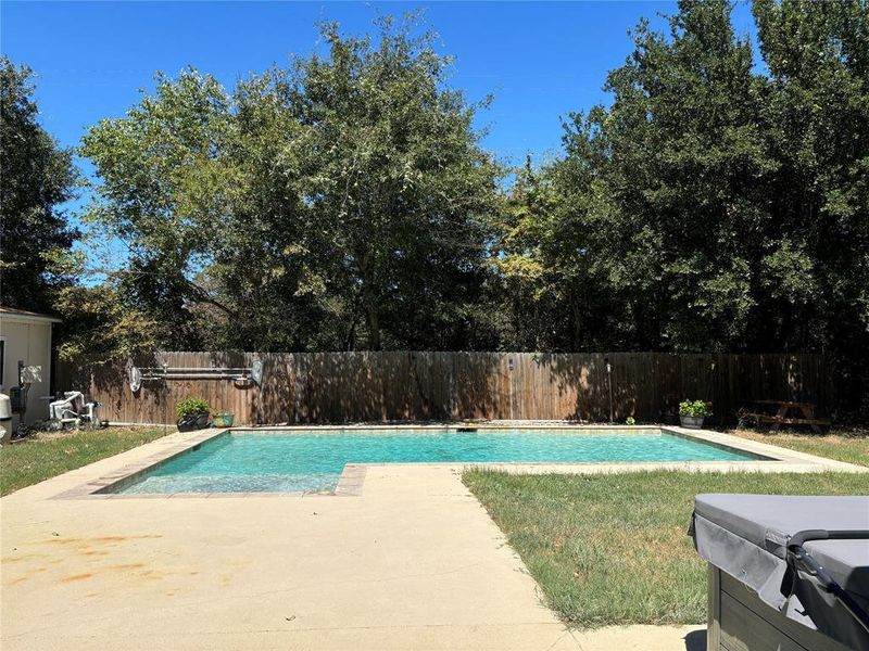 View of swimming pool with a patio area and a hot tub