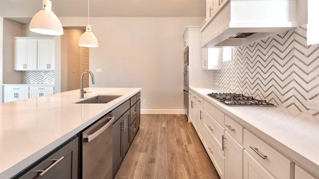 Kitchen with tasteful backsplash, stainless steel appliances, sink, premium range hood, and white cabinetry