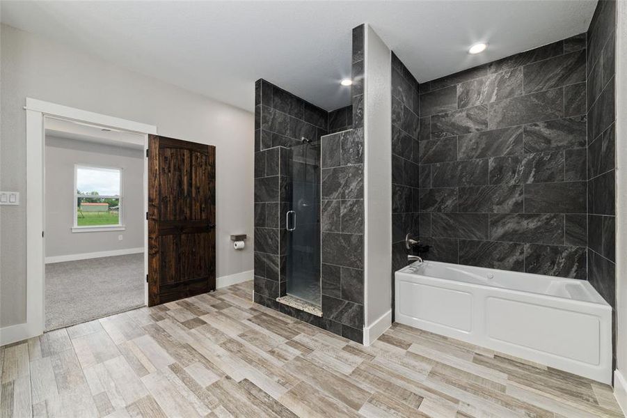 Imagine the endless relaxation awaiting you in the large soaking tub, enveloped by the same elegant dark grey tile that surrounds the shower. This luxurious setting invites you to unwind and rejuvenate in style and comfort.