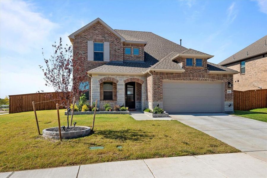 View of front of home with a garage and a front lawn