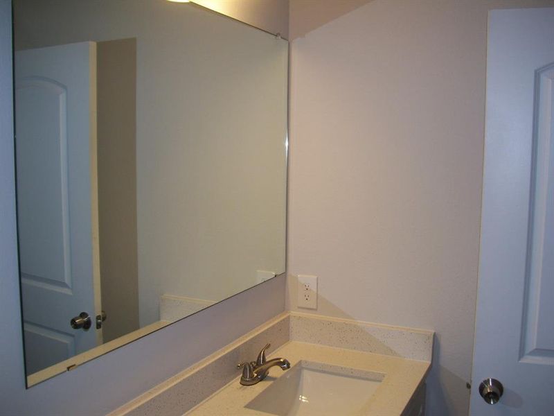 Bathroom featuring vanity with quartz countertop