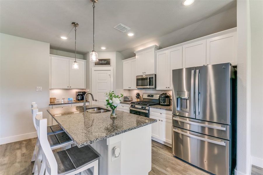 Kitchen featuring white cabinetry, light hardwood / wood-style floors, appliances with stainless steel finishes, and sink