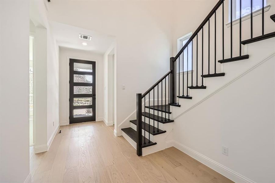 Entrance foyer with light hardwood / wood-style floors and a healthy amount of sunlight