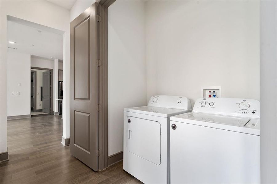 Laundry room with dark hardwood / wood-style floors and washing machine and clothes dryer