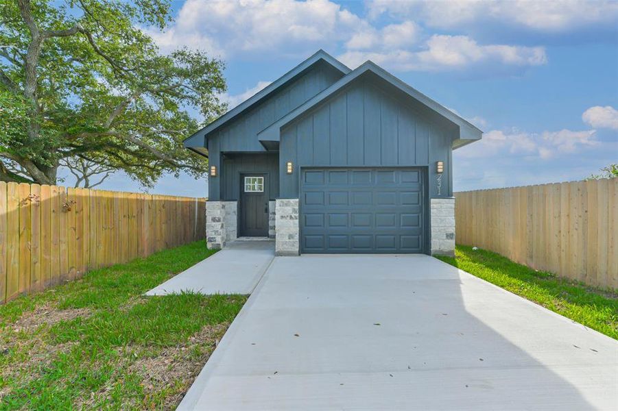 The driveway is wide, leading up to the garage and front