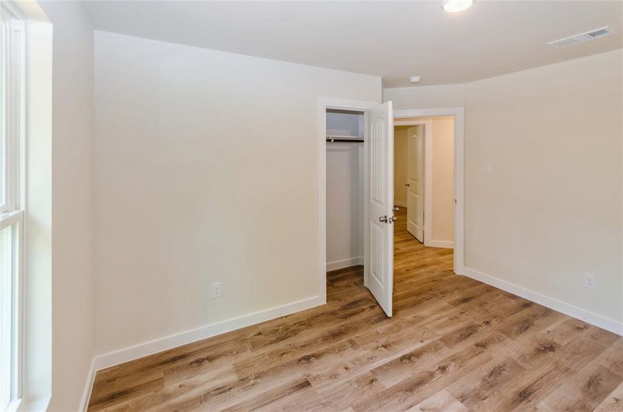 Unfurnished bedroom featuring light wood-type flooring and a closet