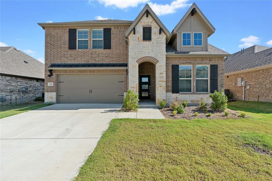 View of front of property featuring a front lawn, central air condition unit, and a garage