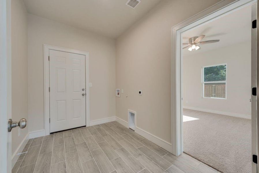 Carpeted empty room featuring ceiling fan