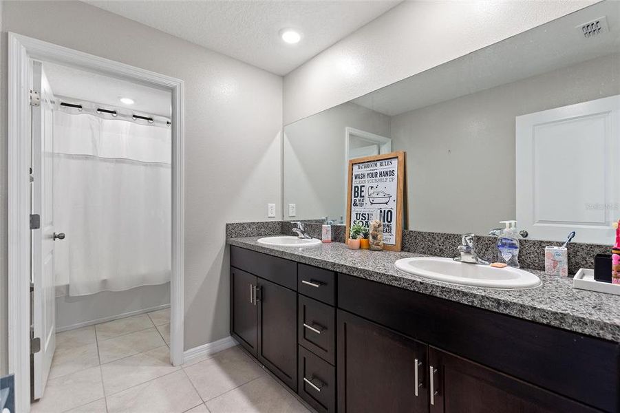 Downstairs Main Bathroom with dual sinks and walk-in shower