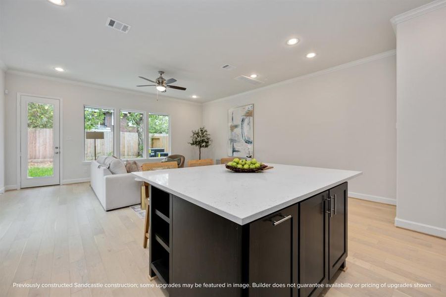 The kitchen's open design seamlessly transitions into the spacious living room, affirming the beauty of an interconnected living space.