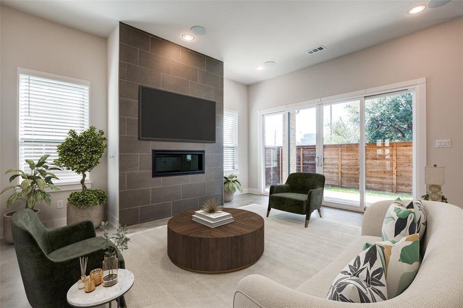 Living room with a healthy amount of sunlight and a tile fireplace (virtually staged)