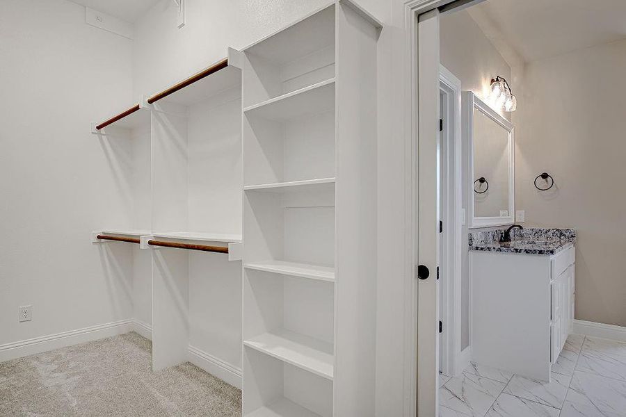 Walk in closet featuring sink and light tile patterned flooring