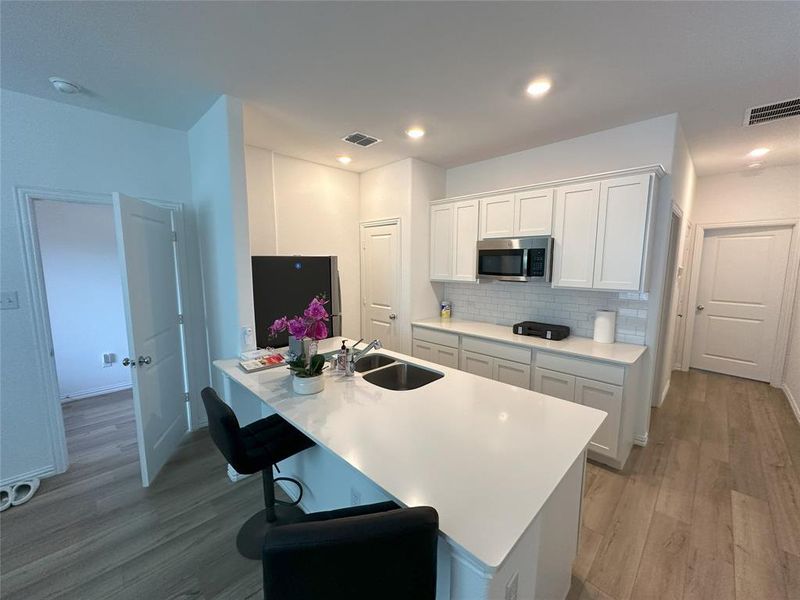 Kitchen featuring white cabinets, light hardwood / wood-style floors, and sink