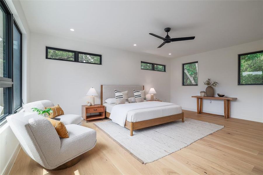The spacious primary bedroom has fantastic neighborhood views through a picture window to the left. Smaller windows on the other two walls preserve privacy, let in diffuse natural light and minimize heat gain on the hotter sides of the home....