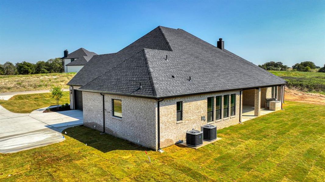 Rear view of property with a lawn and a patio