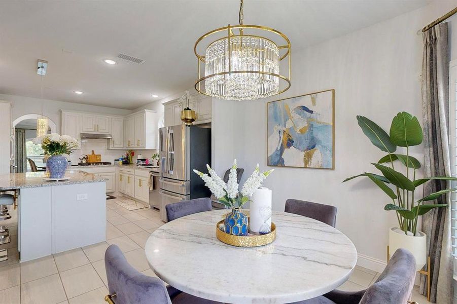 Tiled dining area featuring a notable chandelier