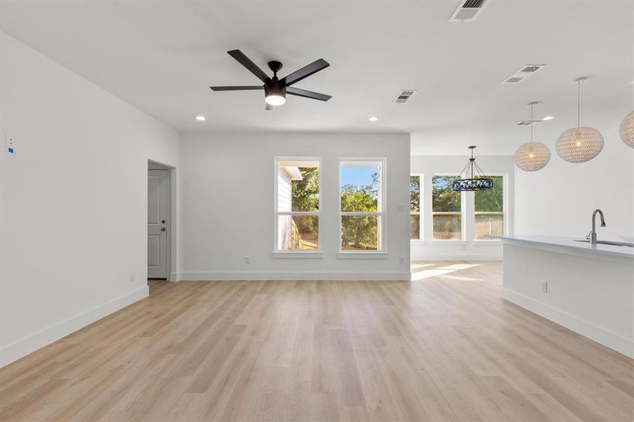 Unfurnished living room with light hardwood / wood-style floors, sink, and ceiling fan