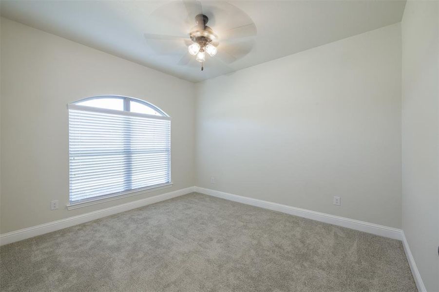 Empty room featuring light carpet and ceiling fan