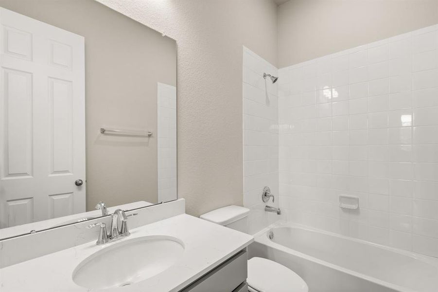 The secondary bath features tile flooring, white cabinetry and light countertops and a shower/tub combo. Perfect for accommodating any visiting family and friends.