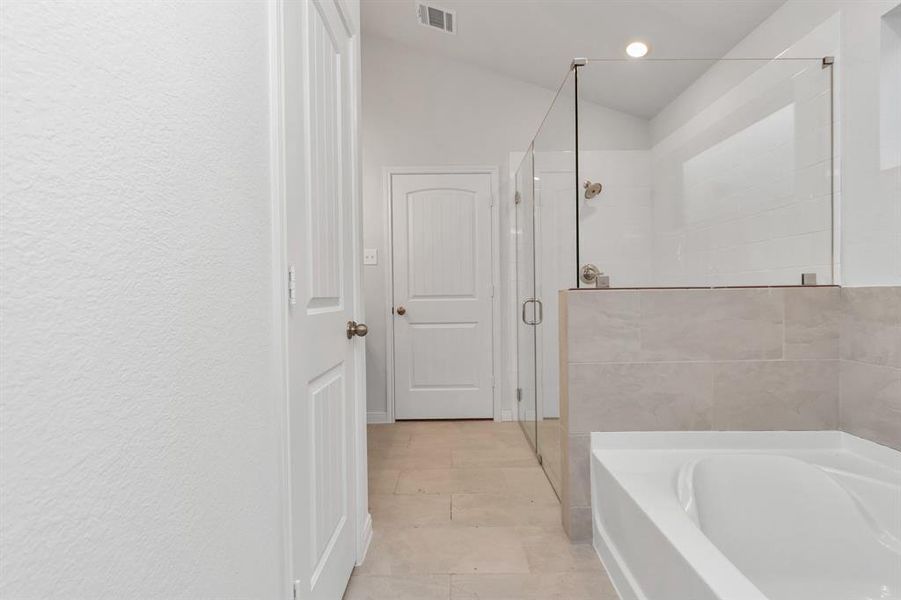 Experience luxury daily in this stunning primary bathroom. Featuring a large glass-enclosed shower, sleek tile flooring, and modern fixtures, it’s designed for both relaxation and efficiency. The separate soaking tub invites you to unwind after a long day. **This image is from another Saratoga Home - Clover floorplan.**