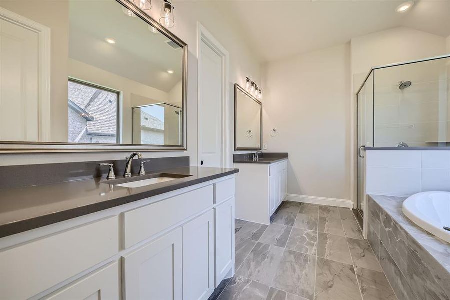 Bathroom featuring shower with separate bathtub, tile patterned flooring, vaulted ceiling, and dual bowl vanity