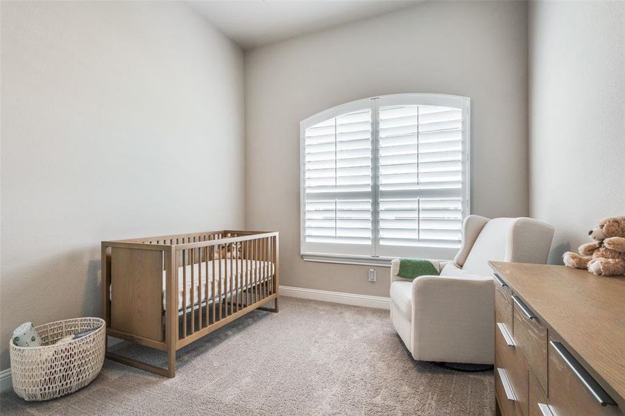 Carpeted bedroom with a crib