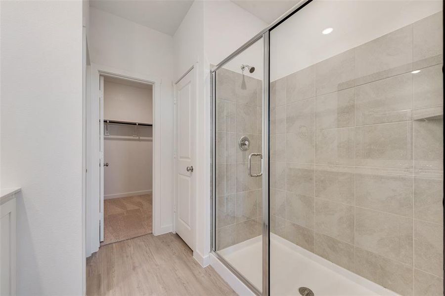 Bathroom featuring vanity, a shower with shower door, and wood-type flooring