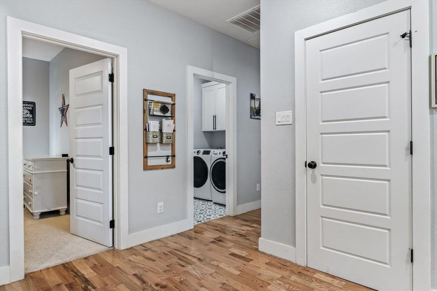 Laundry room featuring cabinets, light hardwood,  washing machine and clothes dryer